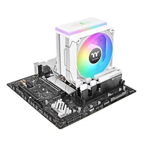 Ein Computer-Mainboard mit einem großen weißen CPU-Kühler, der leuchtet. Mehrere Anschlüsse sind sichtbar, aber keine Peripheriegeräte sind angeschlossen.
