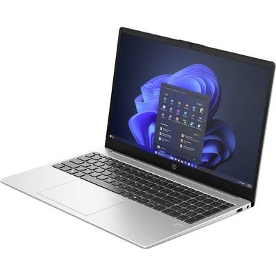 Ein silberner Laptop mit geöffneter Anzeige zeigt den Windows 11-Startbildschirm, auf einem Tisch stehend, im Hintergrund unscharf.