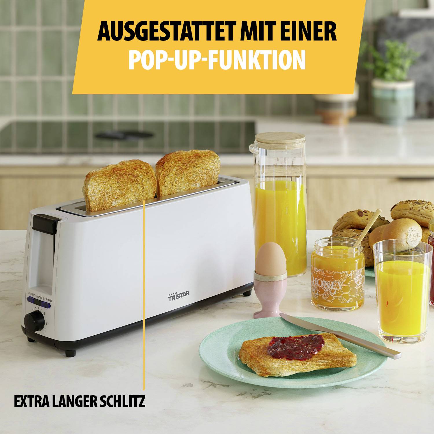 Ein weißer Toaster mit zwei Scheiben Toast. Daneben ein Glas Orangensaft und ein Frühstückstisch mit Aufstrich und Brötchen.