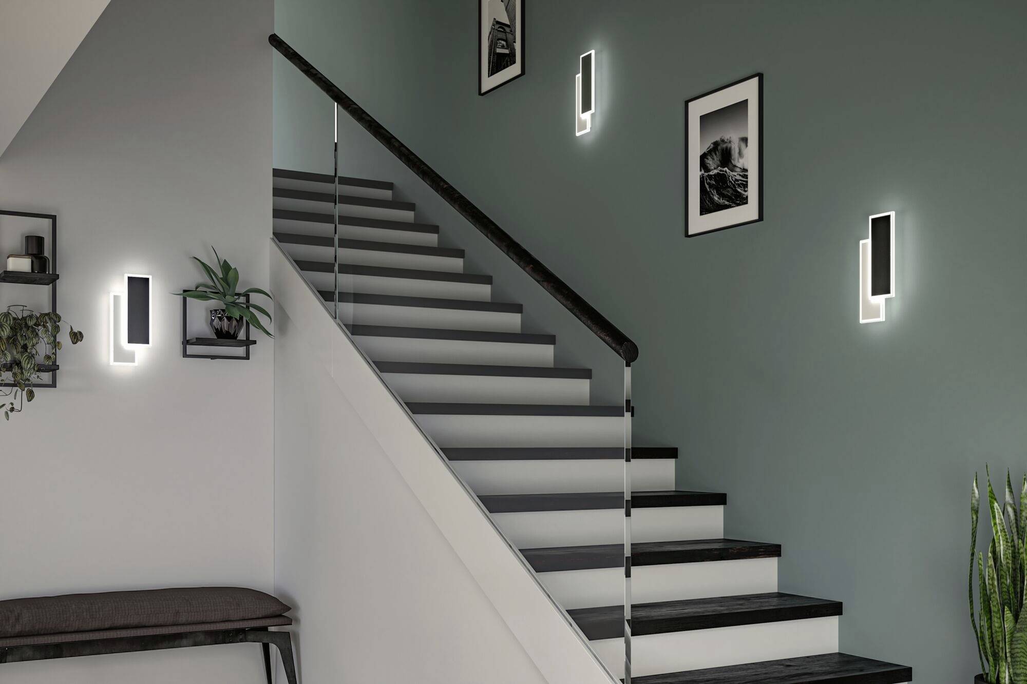 Eine moderne Treppe mit dunklen Stufen, umgeben von Wandlampen und schwarz-weißen Fotos an einem mintgrünen Hintergrund.
