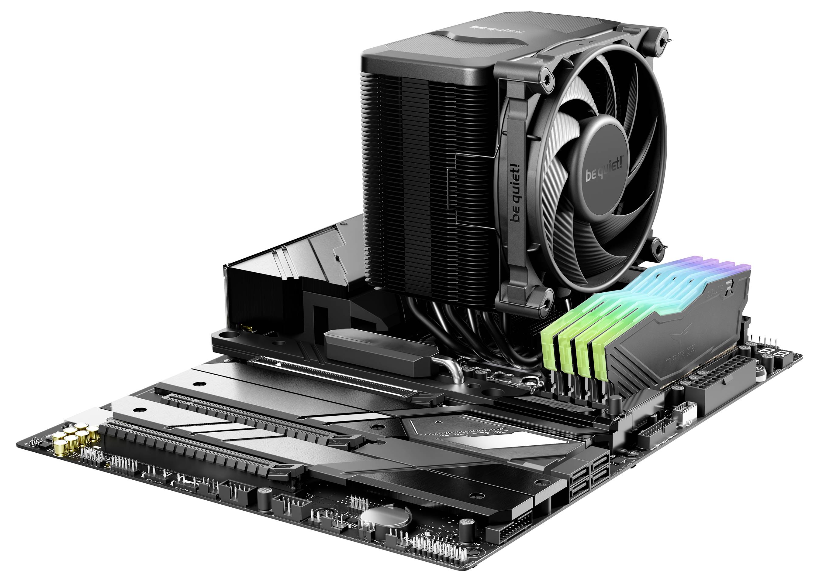 Mainboard mit CPU-Kühler und RGB-beleuchteten RAM-Speichern. Der Kühler ist schwarz, und die RAM-Sticks zeigen bunte Lichter.