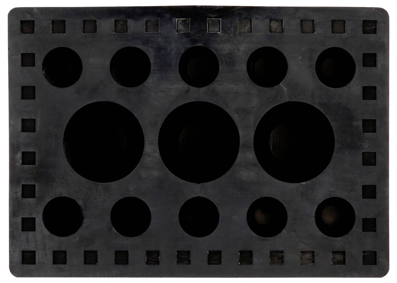Eine schwarze Kunststoffplatte mit verschiedenen kreisförmigen Aussparungen unterschiedlicher Größe.