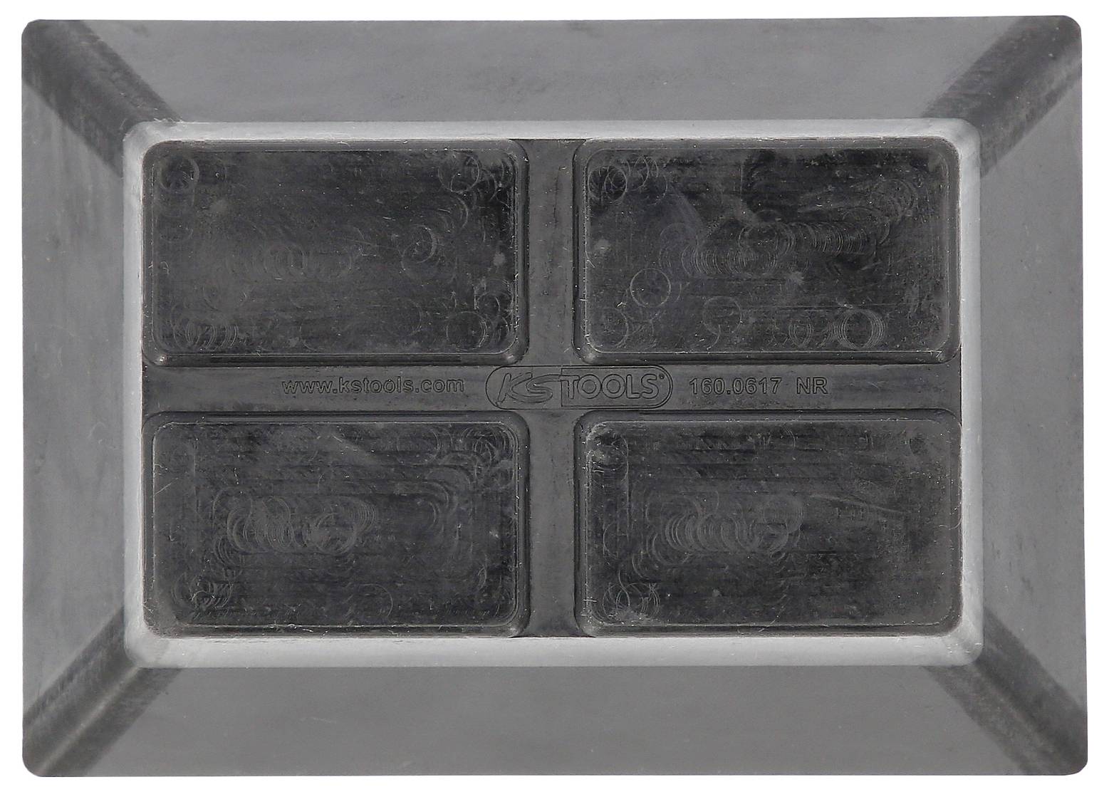 Ein graues, rechteckiges Objekt mit vier abgeteilten Abschnitten in der Mitte. Oberfläche ist gleichmäßig dunkel und strukturiert.