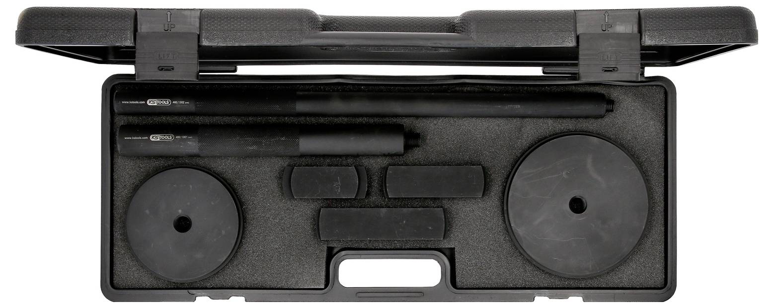 Ein offener schwarzer Koffer enthält präzise verpackte Werkzeuge, darunter zwei runde Platten und zwei lange Stäbe aus schwarzem Material.