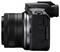 Seitliche Ansicht einer schwarzen digitalen Spiegelreflexkamera mit Mikrofonanschluss, zeigt Bedienelemente und Objektivdetails.