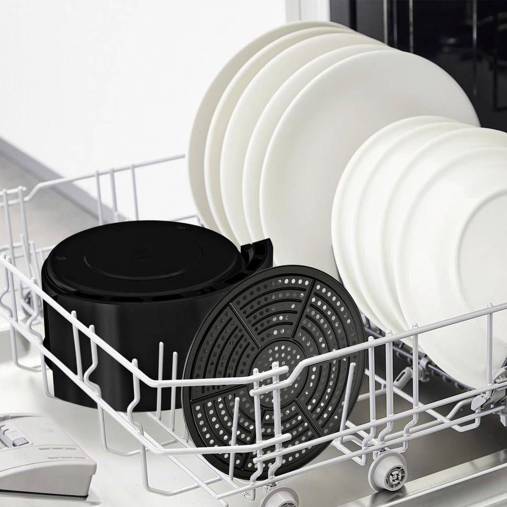 Geschirrspülerkorb mit weißen Tellern und einem großen schwarzen Topfdeckel, ordentlich angeordnet, bereit zum Spülen.