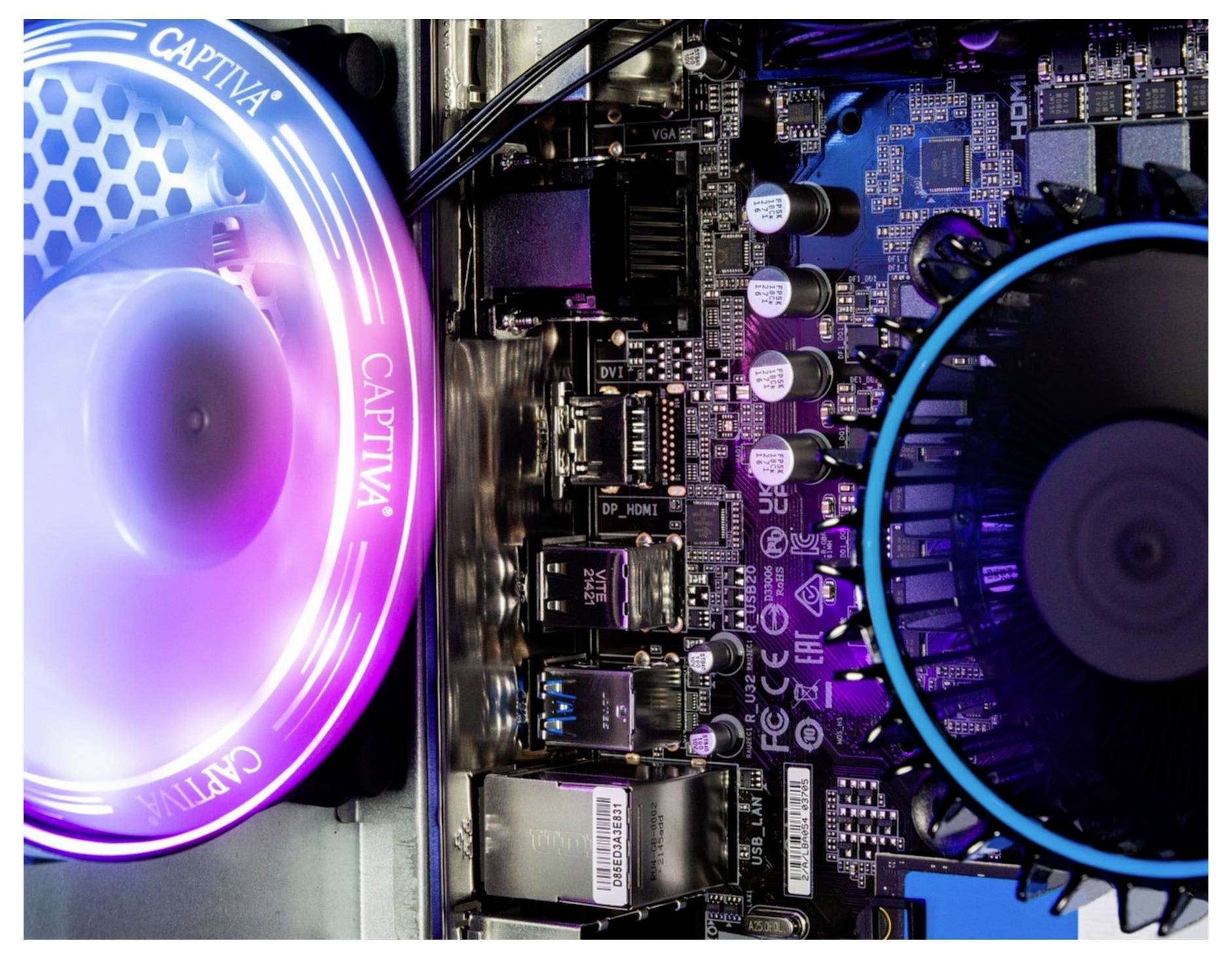 Innenansicht eines Computergehäuses mit beleuchtetem Lüfter und Hauptplatine. Die Beleuchtung zeigt ein farbiges Leuchten.