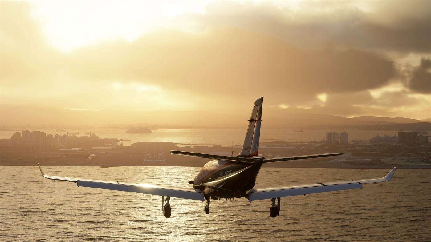 Ein kleines Flugzeug fliegt bei Sonnenuntergang über das Meer, im Hintergrund sind die Umrisse einer Stadt und Berge zu sehen.