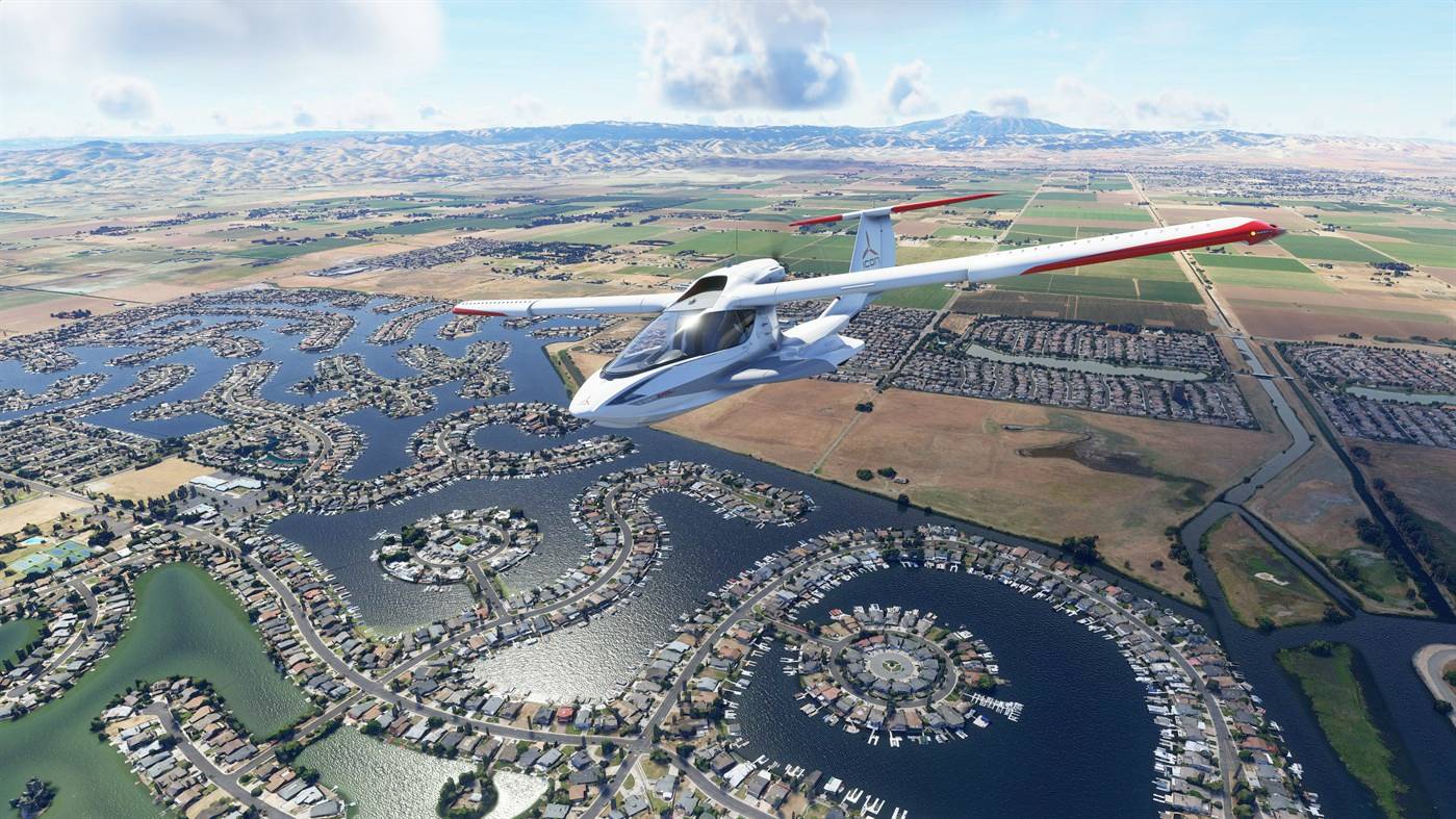 Ein Leichtflugzeug fliegt über eine weitläufige Landschaft mit Flüssen und Feldern, unter einem klaren, blauen Himmel mit wenigen Wolken.