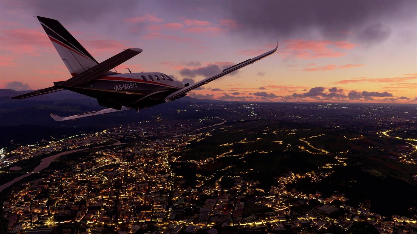 Ein kleines Flugzeug fliegt bei Sonnenuntergang über eine beleuchtete Stadt, die sich unter einem bewölkten Himmel erstreckt.