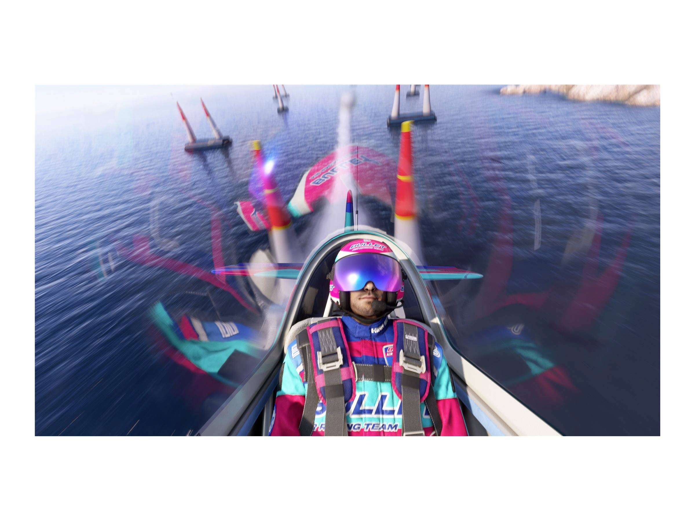 Pilot fliegt Kunstflugzeug über Wasser zwischen roten Bojen. Pilot trägt Helm und bunte Schutzbrille. Ozean und Himmel im Hintergrund.