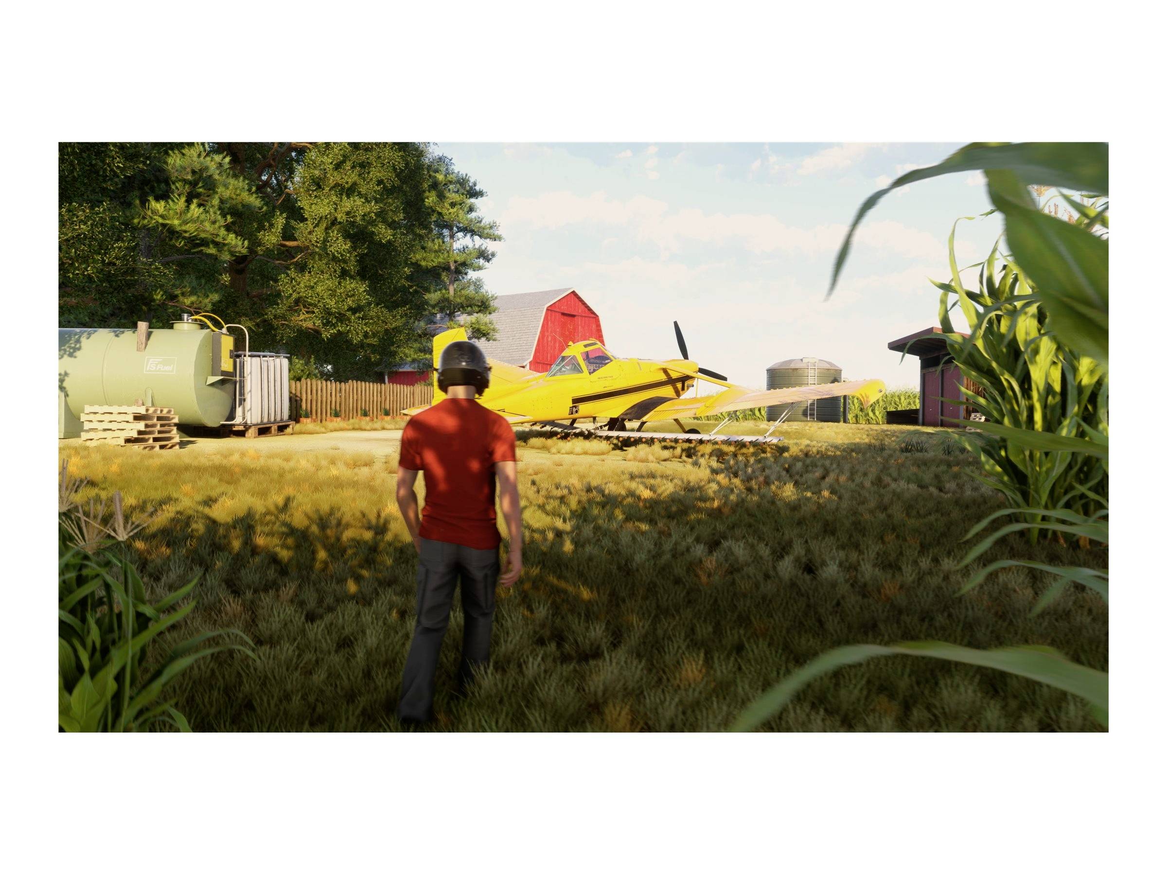 Eine Person in rotem T-Shirt geht in Richtung gelbem Flugzeug auf einem ländlichen Hof mit Bäumen und landwirtschaftlichen Gebäuden.