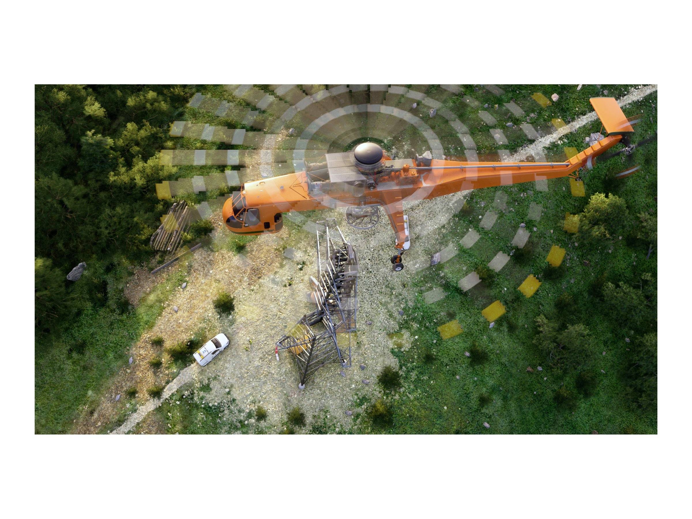 Hubschrauber transportiert eine Metallstruktur über einen Wald, darunter ein Fahrzeug am Boden.