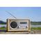 Ein Radio im Retro-Stil steht auf einem Holztisch vor einer natürlichen Landschaft. Auf dem Display steht 'Klassik Radio'.