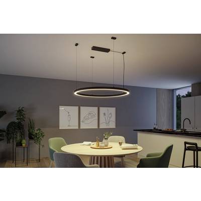 Esszimmer mit rundem Tisch und modernen Stühlen, zentrale Hängelampe leuchtet. Drei minimalistische Kunstwerke an der Wand.