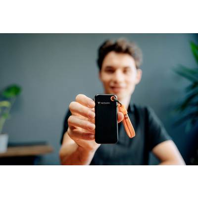 Eine Person hält ein tragbares Speichergerät mit einem orangefarbenen USB-Stick. Hintergrund ist unscharf, Fokus liegt auf dem Gerät.