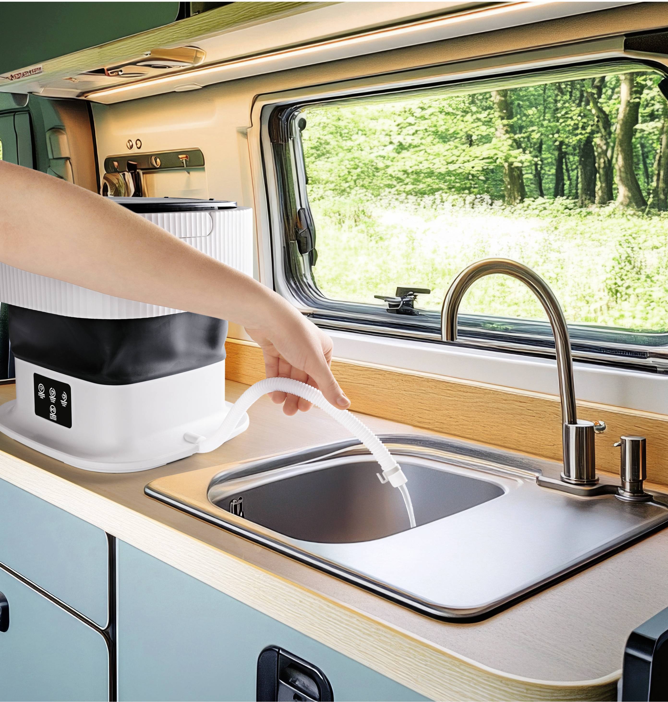 Eine Person füllt Wasser in ein Waschbecken in einem Wohnmobil. Ein kompaktes Gerät mit Schlauch befindet sich auf der Arbeitsplatte.