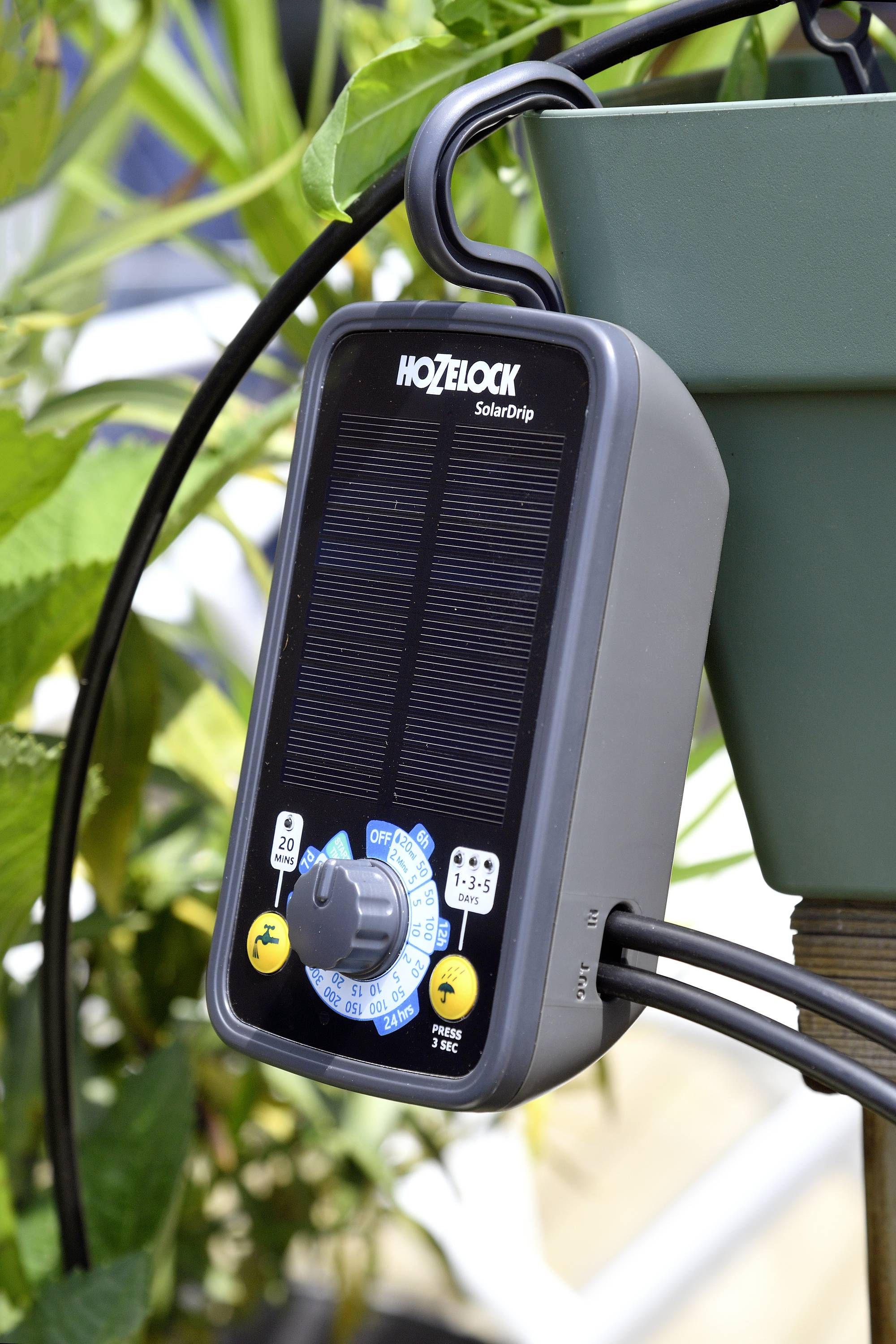 Bewässerungstimer mit Solarpanel, aufgehängt an einem Topf, zeigt ein Drehzifferblatt für Zeiteinstellungen.