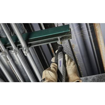 'Eine Person schneidet mit einem Dremel-Werkzeug ein Metallrohr. Funken fliegen. Trägt Arbeitshandschuhe für Sicherheit.'