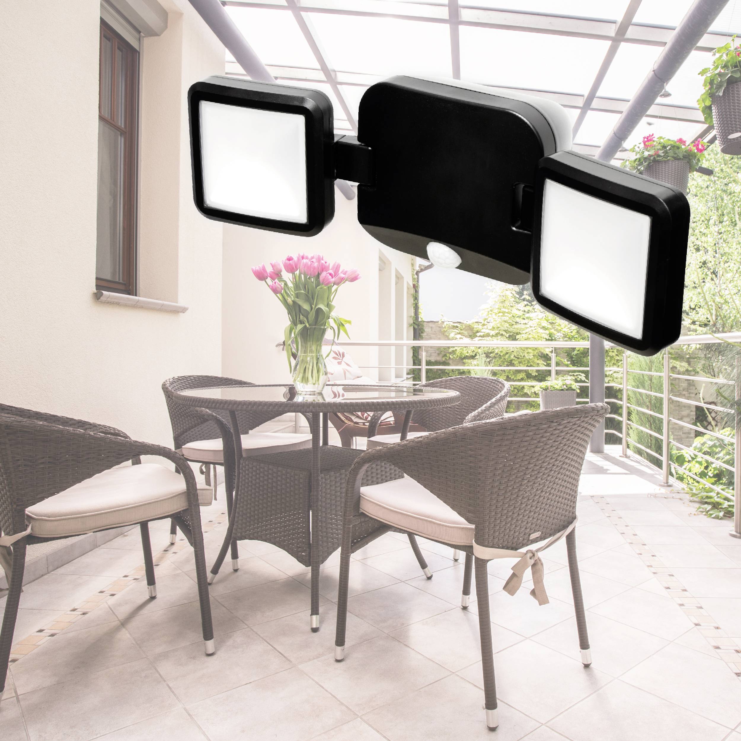 Beleuchtete Terrasse mit Tisch und Stühlen; eine moderne Außenleuchte mit zwei quadratischen Strahlern sorgt für Helligkeit.