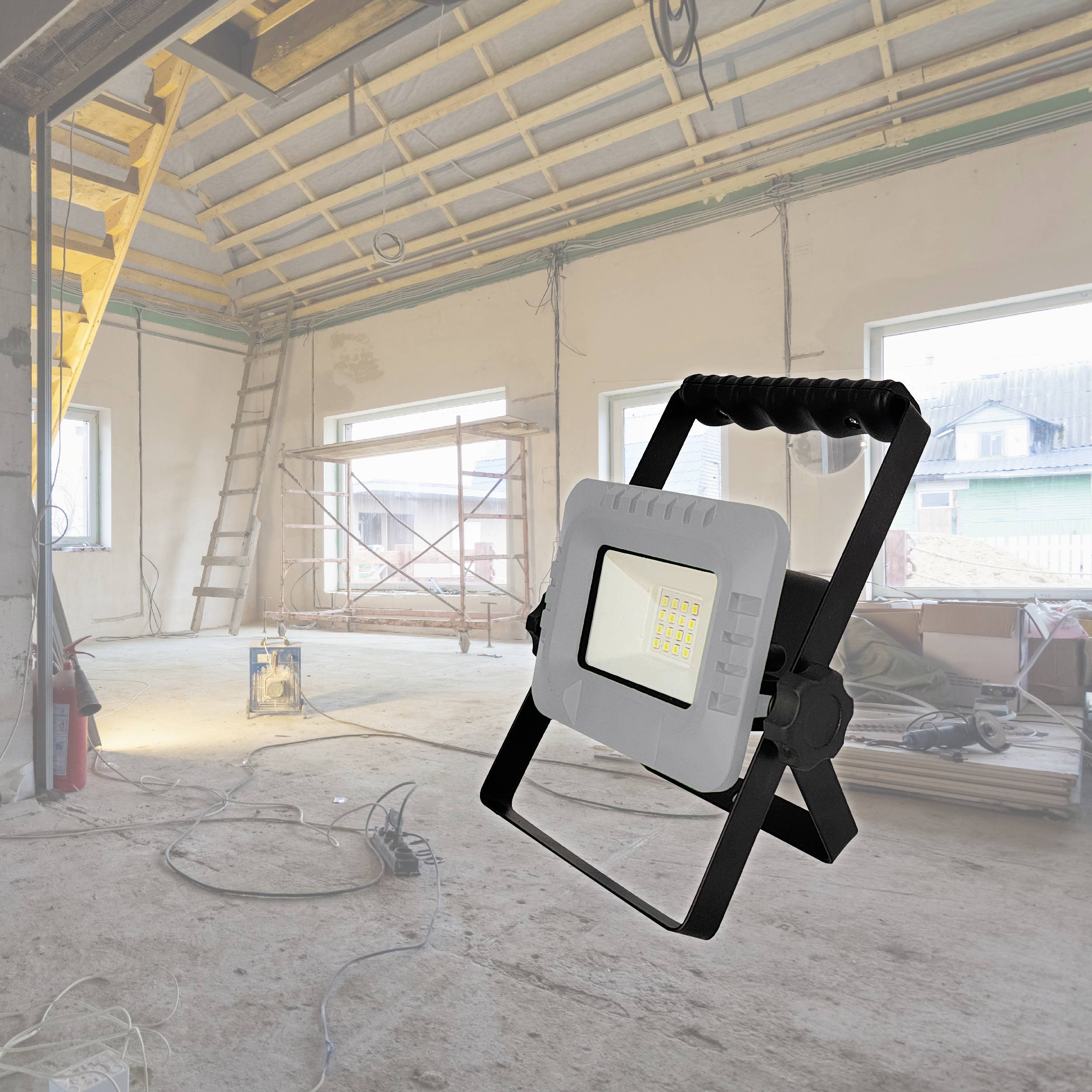 Baustelle mit Lampen in großem Raum, Fenstern, Leitern und Gerüst, leuchtstarke Flutlichter im Vordergrund für klare Sichtbarkeit.