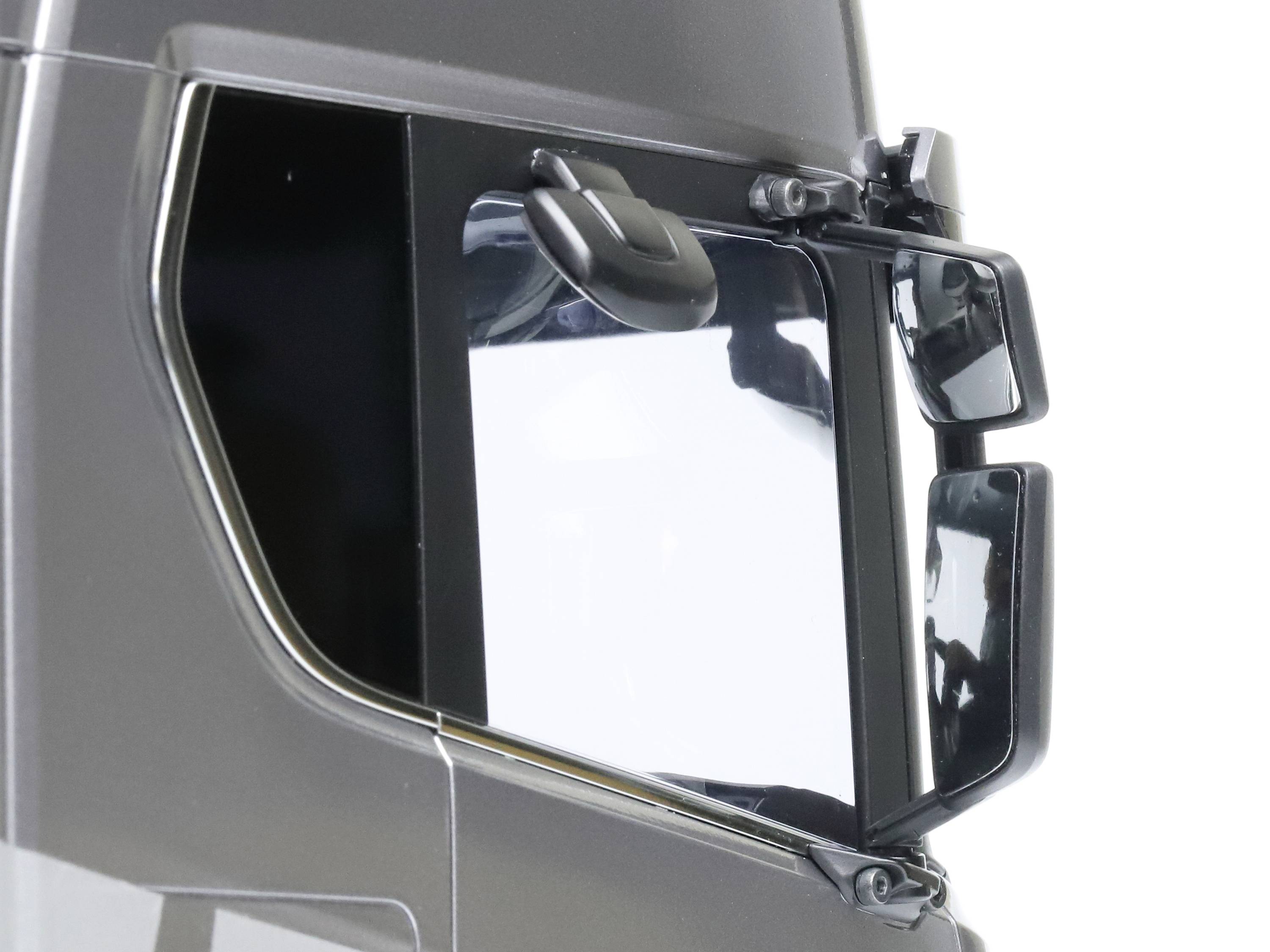 Ein Teil eines modernen Lkw-Fahrerhauses, das eine Seitenscheibe und Seitenspiegel zeigt. Die Spiegel sind ausgeklappt für optimale Sicht.