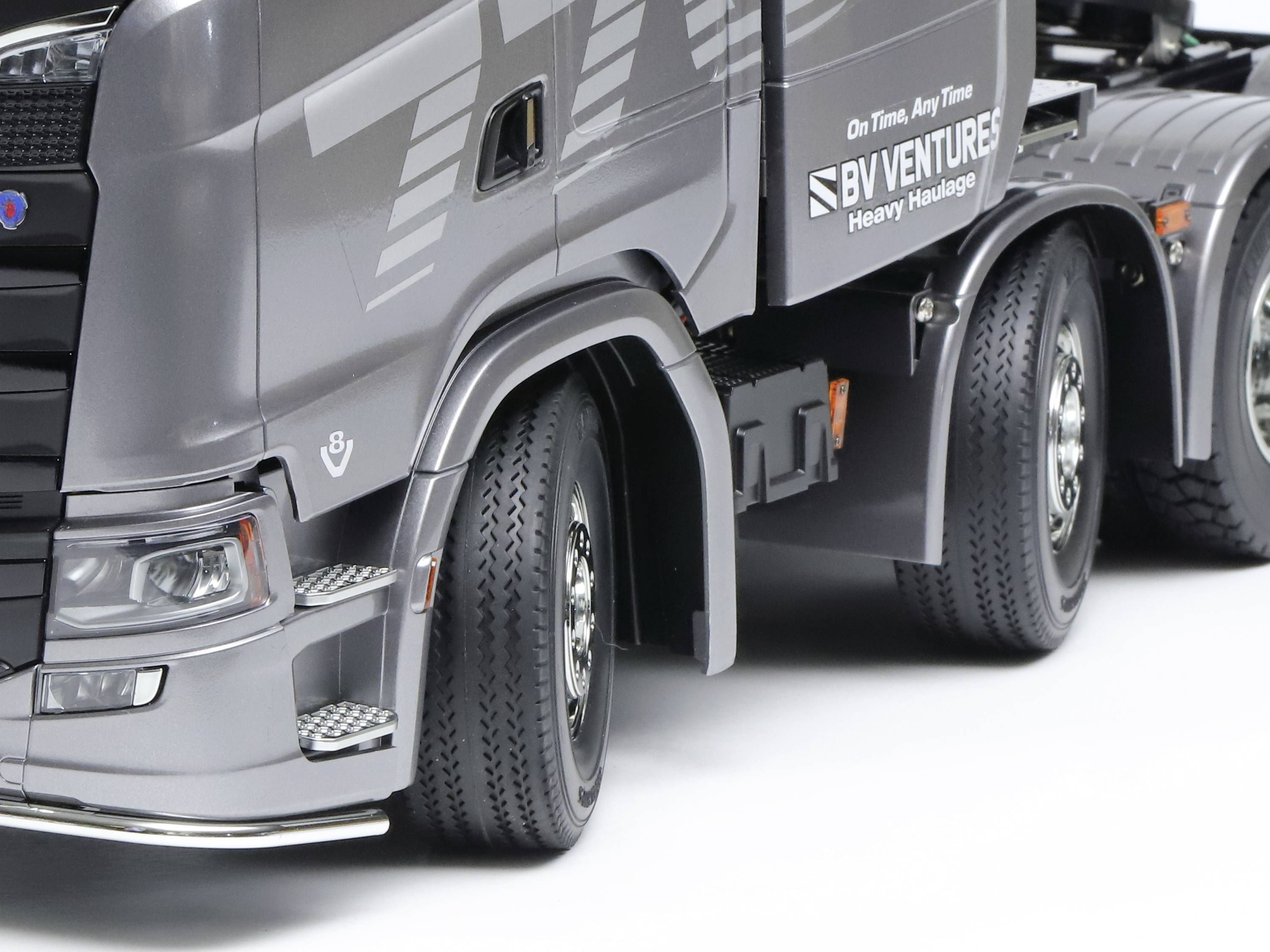Grauer Lastwagen mit Logo 'BV VENTURES Heavy Haulage'. Zeigt Vorder- und Hinterräder auf weißem Hintergrund.