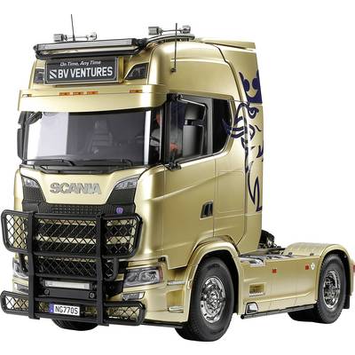 Goldener Lastwagen von Scania mit dekorativen Seitengrafiken, geparkt und im Profil sichtbar.