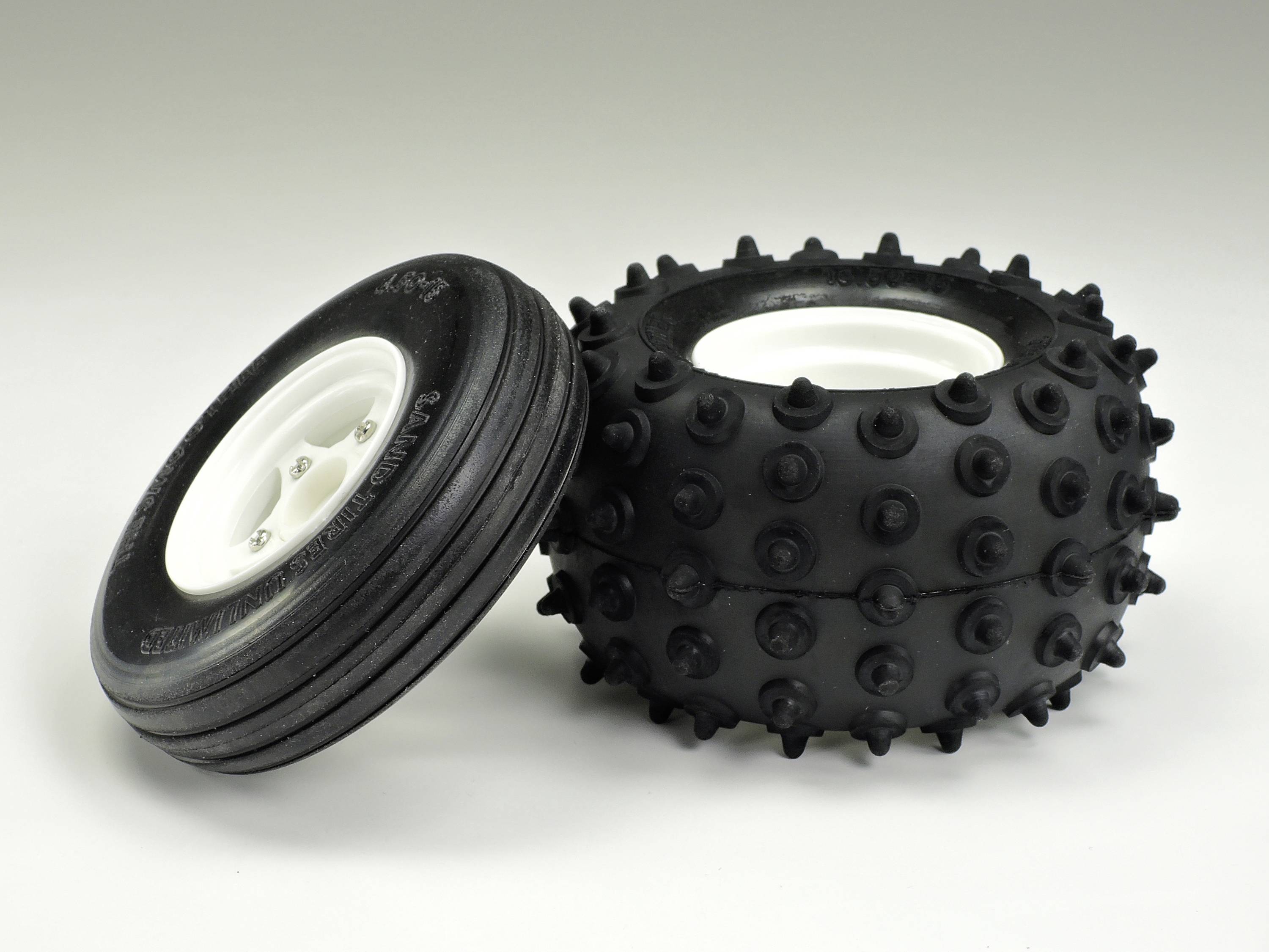 Zwei verschiedene Reifen: links ein dünner, glatter Reifen für Straßen, rechts ein dicker, grobstolliger Reifen für Geländefahrten.