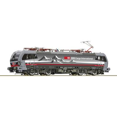 Grau-schwarze Lokomotive der SBB Cargo International mit Bergmotiv auf der Seite, Fahrdrähte oben und technische Details sichtbar.