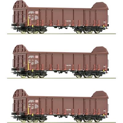 Drei identische Modelleisenbahn-Güterwagen der Deutschen Bahn in rotbrauner Farbe, nebeneinander auf Gleisen stehend.