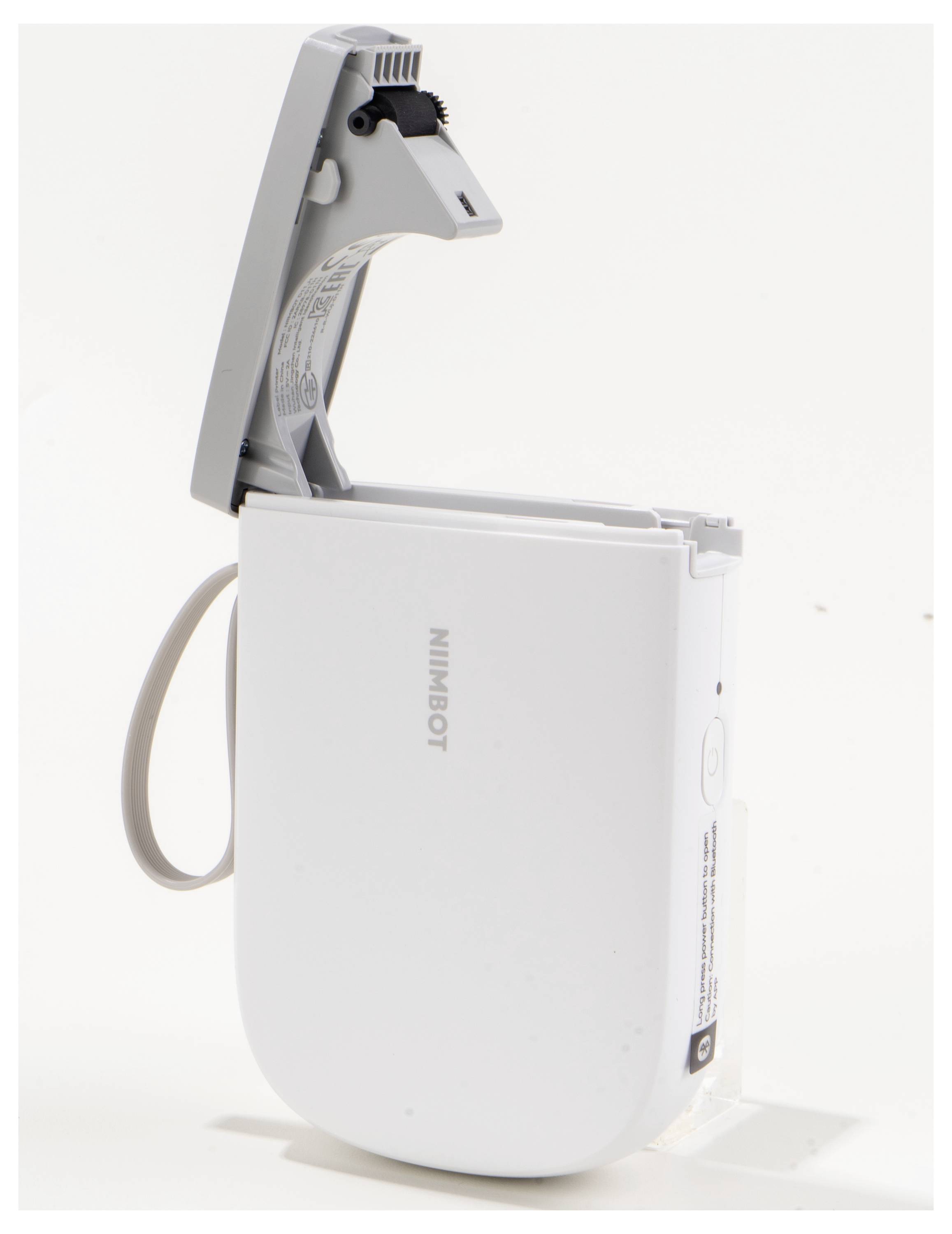 Ein kleiner, weißer Etikettendrucker mit geöffneter Klappe und einer eingelegten Papierrolle in einer schlichten, modernen Form.