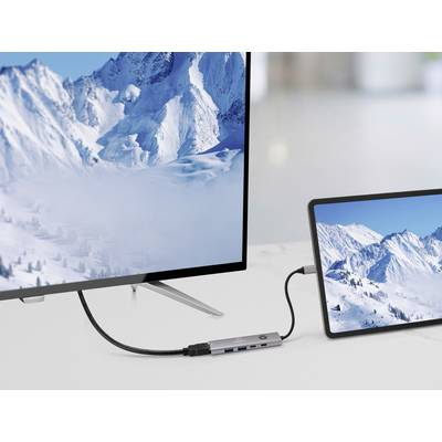 Ein Tablet ist mit einem großen Bildschirm verbunden, beide zeigen schneebedeckte Bergketten und veranschaulichen eine Bildschirmfreigabe-Einrichtung in einer modernen Umgebung.