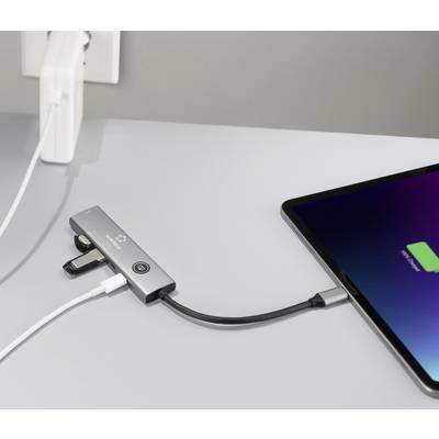 Ein Tablet, das mit einem Multi-Port-Adapter verbunden ist, welcher an eine Stromquelle angeschlossen ist, zeigt das Laden durch ein Ladesymbol auf dem Bildschirm an.