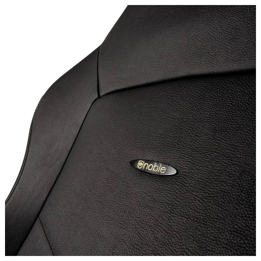 Ein Close-up eines noblechairs-Sitzes aus schwarzen Kunstleder mit Logo. Der Fokus liegt auf den texturierten Materialien und der Marke.