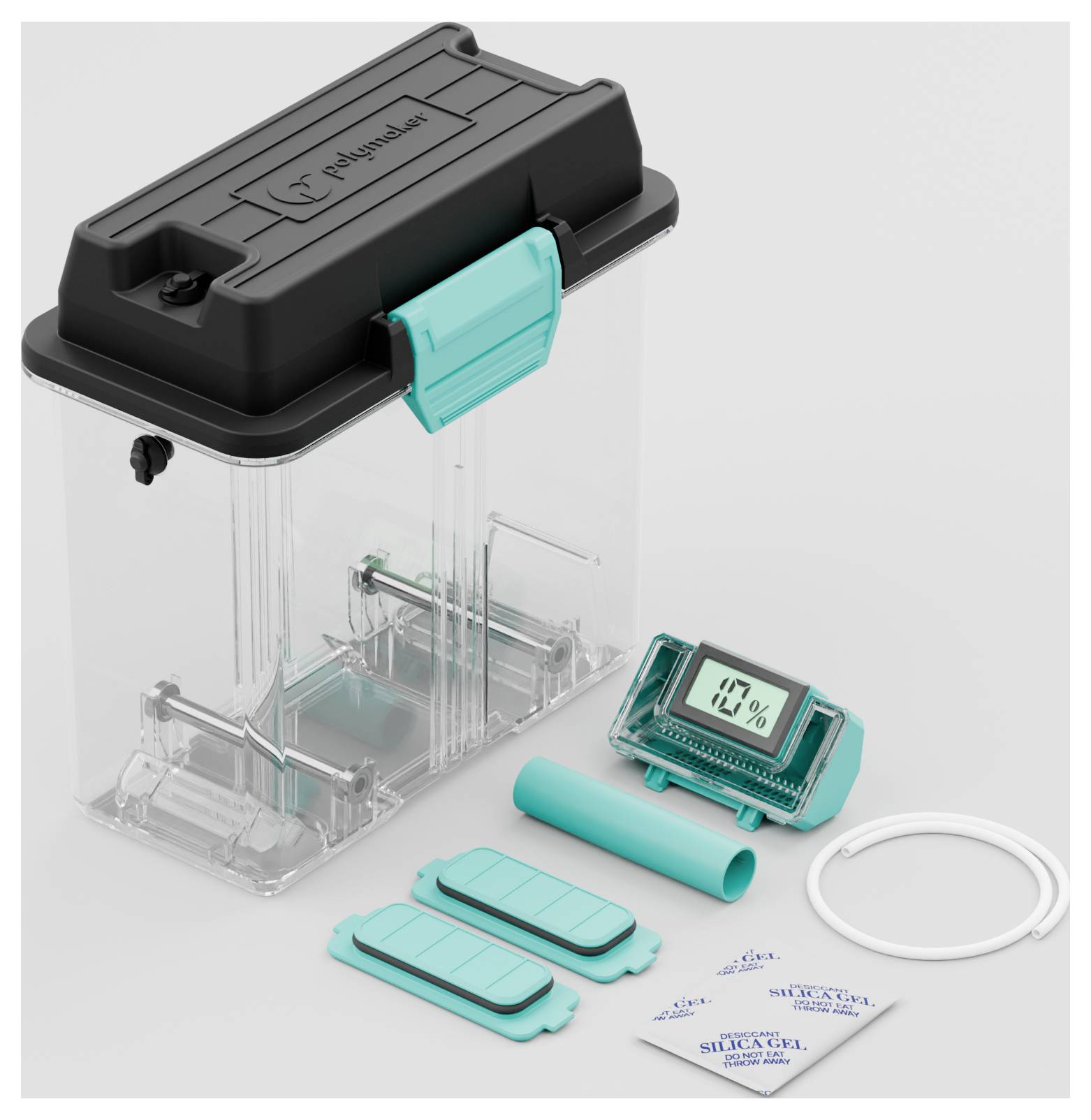 Eine durchsichtige Kunststoffbox mit schwarzem Deckel und türkisfarbenen Verschlüssen; enthält ein Hygrometer und Silikagel-Päckchen.