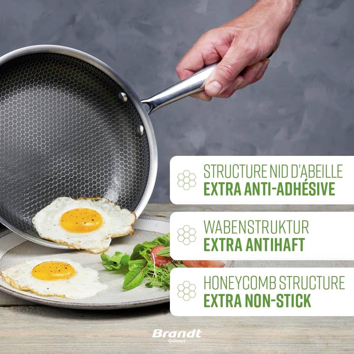 Eine Hand hält eine Bratpfanne mit Wabenmuster und einem gebratenen Ei. Die Verpackungsbeschriftung betont 'Extra Anti-Haftstruktur'.