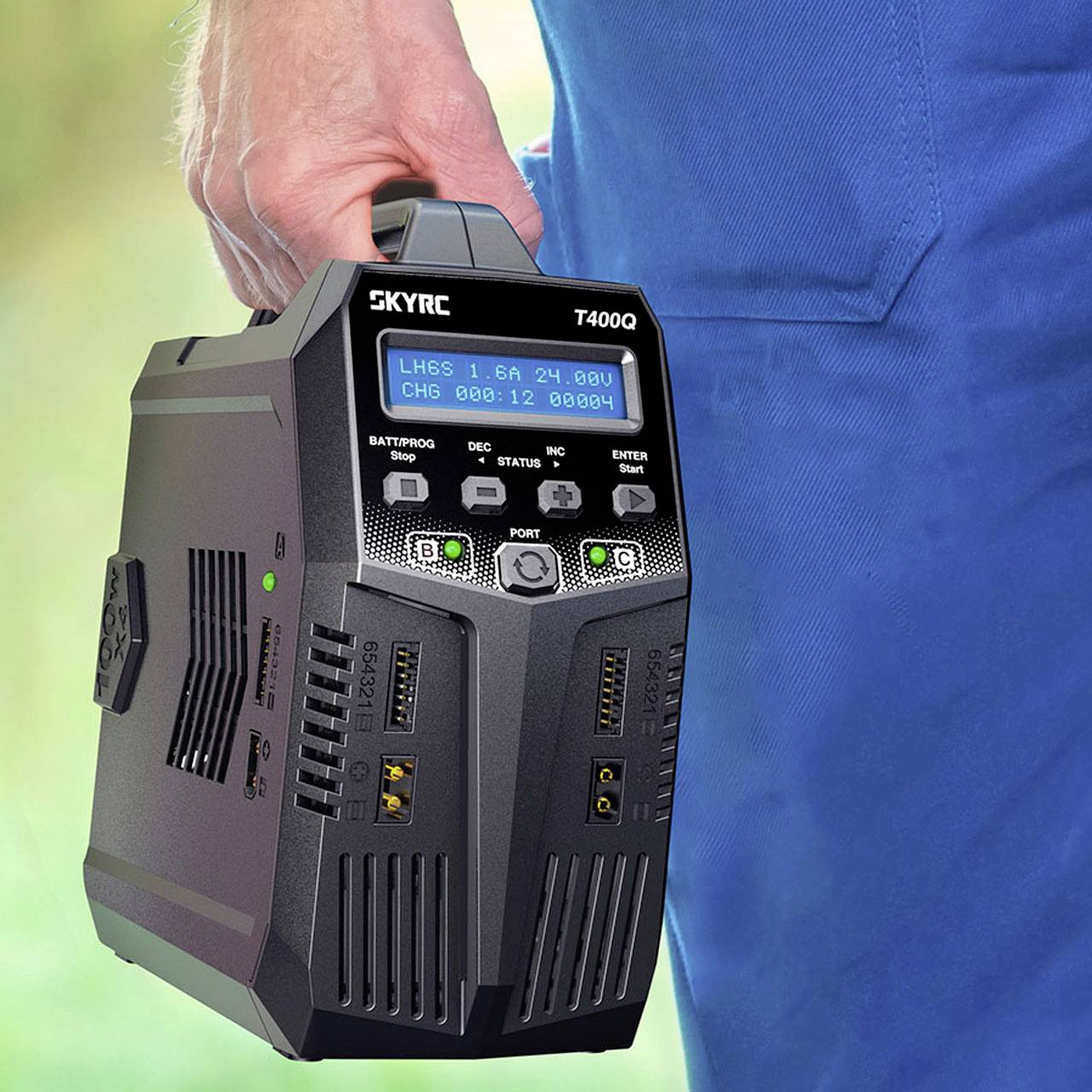 Eine Person hält ein SKYRC T400Q Ladegerät in der Hand. Das Ladegerät zeigt auf dem Display Ladevorgangsinformationen an.