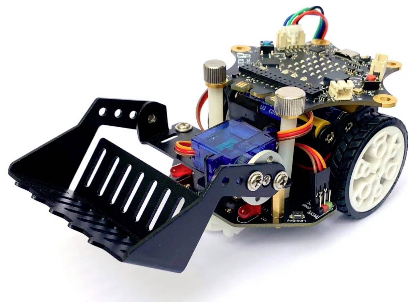 Ein kleiner Roboter mit Rädern, einer schwarzen Schaufel vorne und mehreren Kabeln auf der Oberseite, geeignet für Elektronikprojekte.