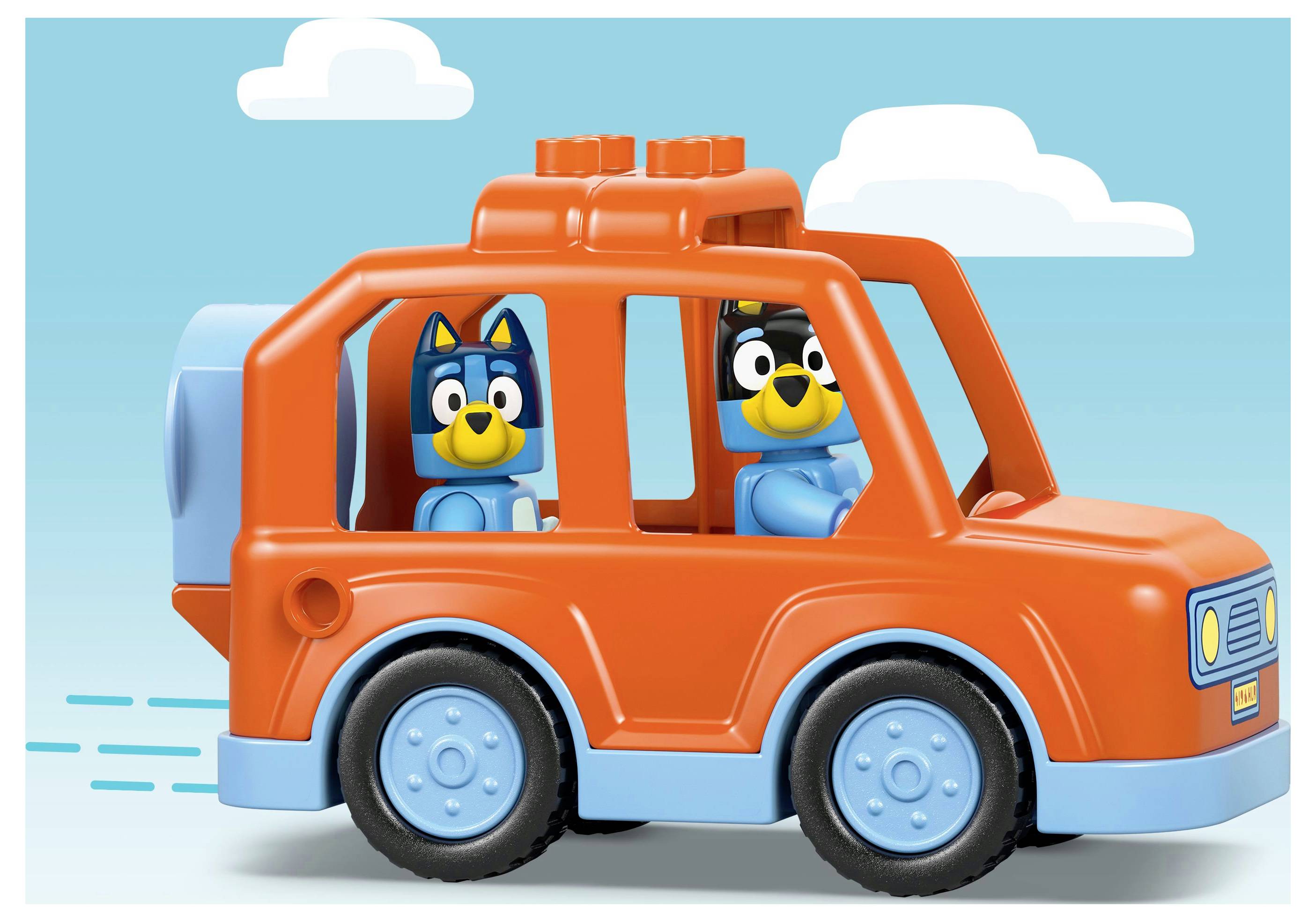 Spielzeugblockfiguren, die Hunden ähneln, in einem hellorangefarbenen Spielzeugauto auf blauem Hintergrund.