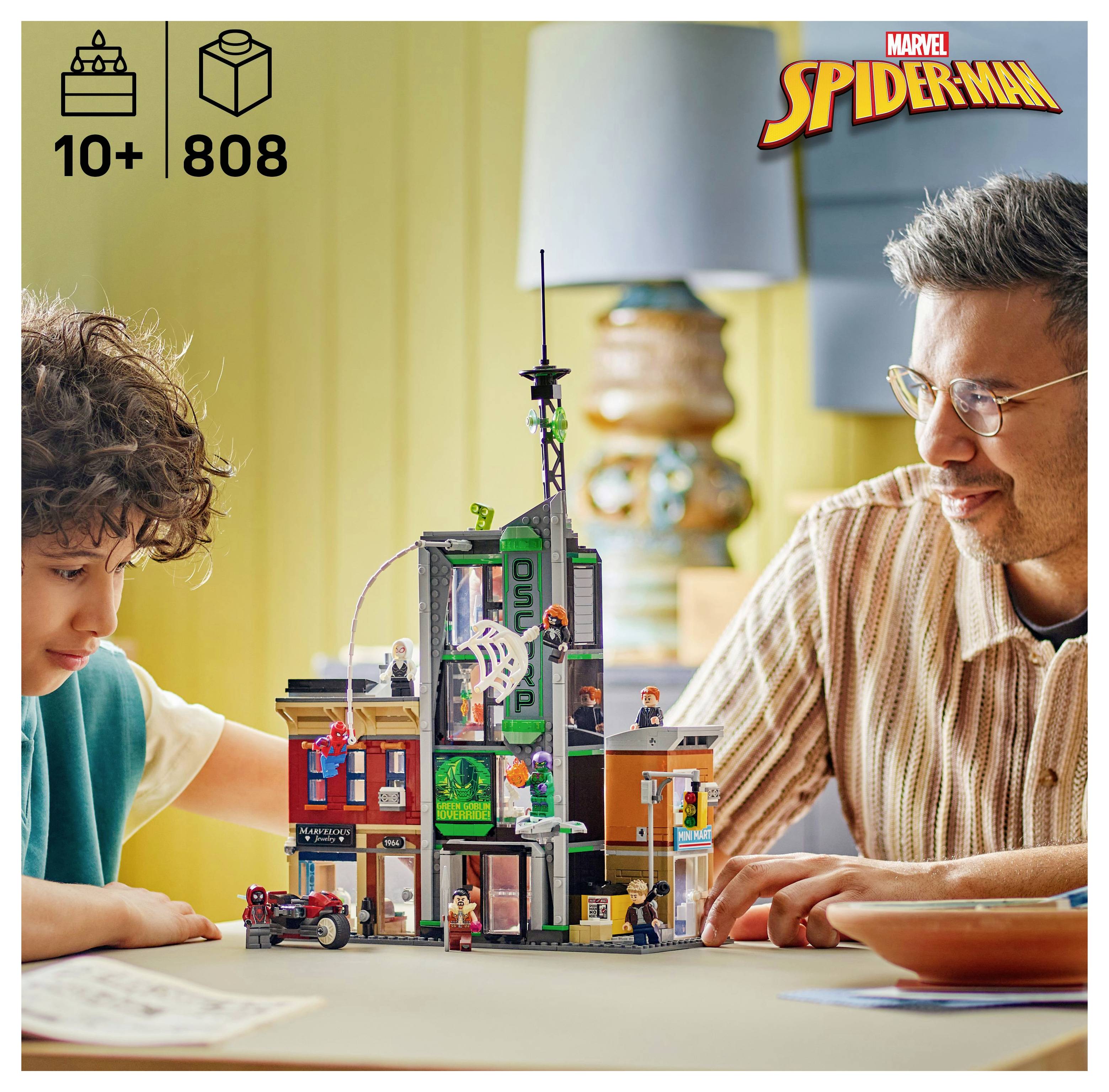 Ein Kind und ein Erwachsener bauen einen detaillierten LEGO-Set mit Stadtthema und Spider-Man-Branding. Der Set umfasst verschiedene Stadtelemente und Figuren.