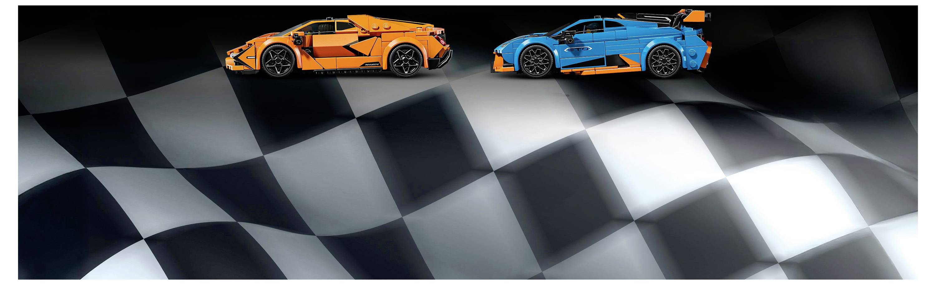 Zwei Spielzeug-Rennwagen, einer orange und einer blau, auf einer karierten Oberfläche, die einer Rennstrecken-Ziellinie ähnelt.