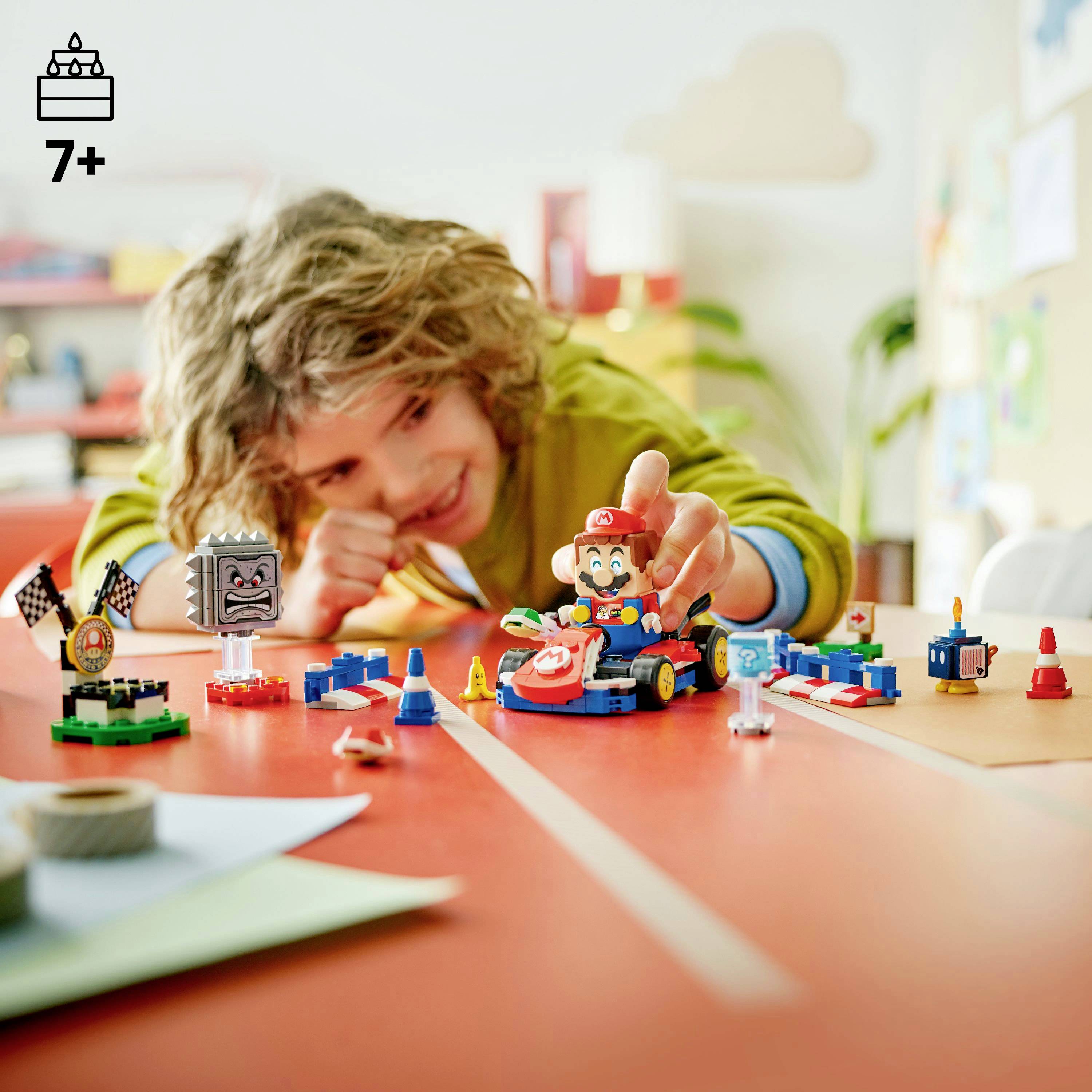 Ein Kind spielt begeistert mit einem bunten Spielzeugauto-Set auf einem Tisch, umgeben von verschiedenen Spielzeugzubehören, und betont dabei Kreativität und Spaß.