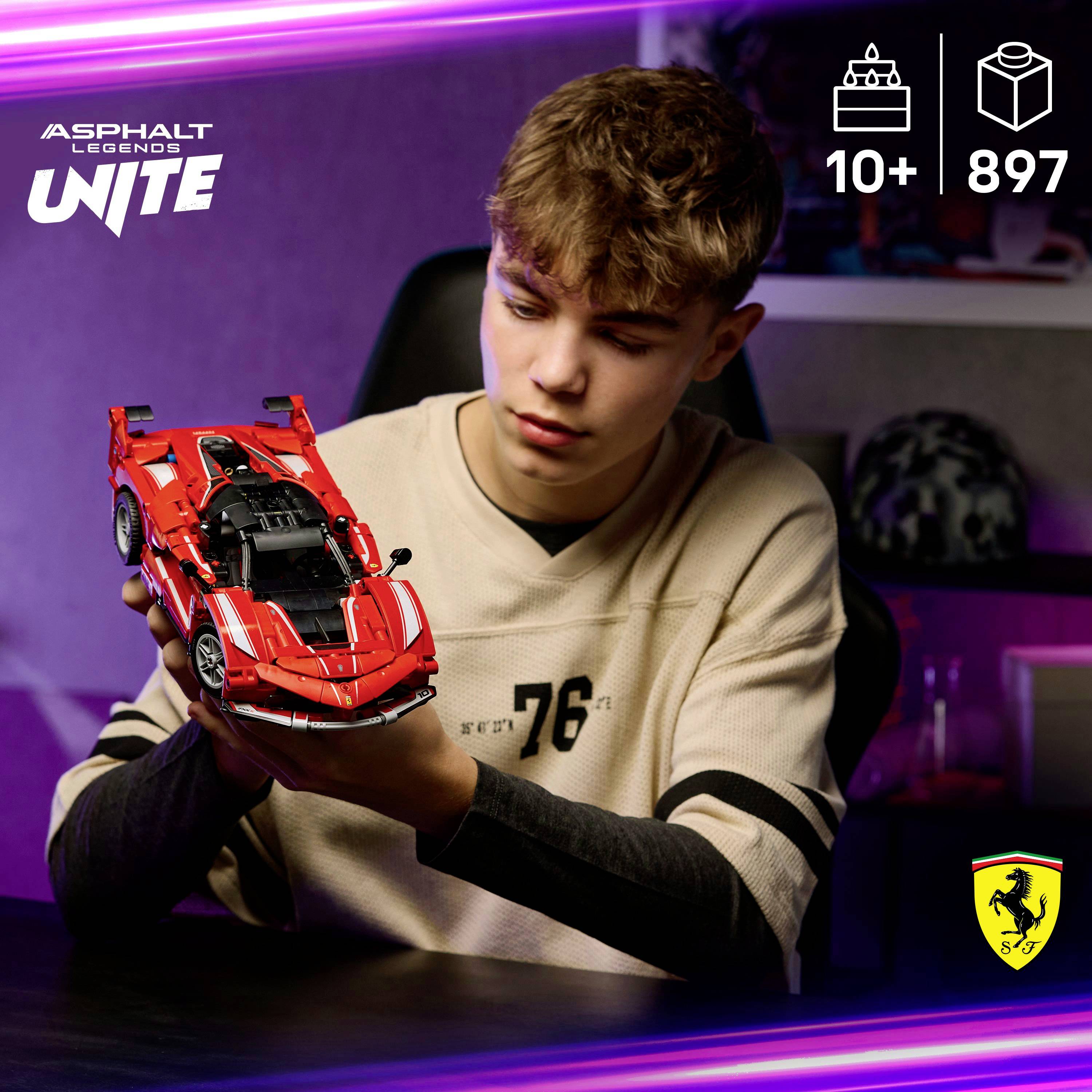 Junger Mensch, der ein detailliertes Modell eines roten Sportwagens hält und konzentriert aussieht. Das Bild deutet auf ein Interesse an automobiler Handwerkskunst hin.