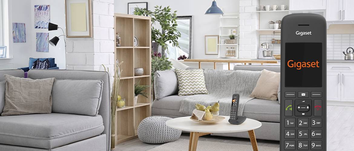 Wohnzimmer mit modernen Möbeln und Dekorationen. Im Vordergrund steht ein Tischtelefon der Marke 'Gigaset'.