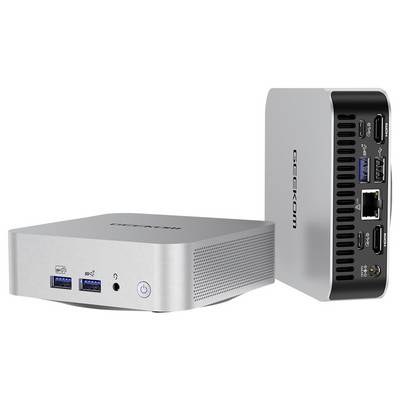 Ein kompakter Desktop-Computer in Silber zeigt Vorder- und Rückseite. Vorne: USB-Anschlüsse, Kopfhörerbuchse, Power-Button. Hinten: diverse Anschlüsse.