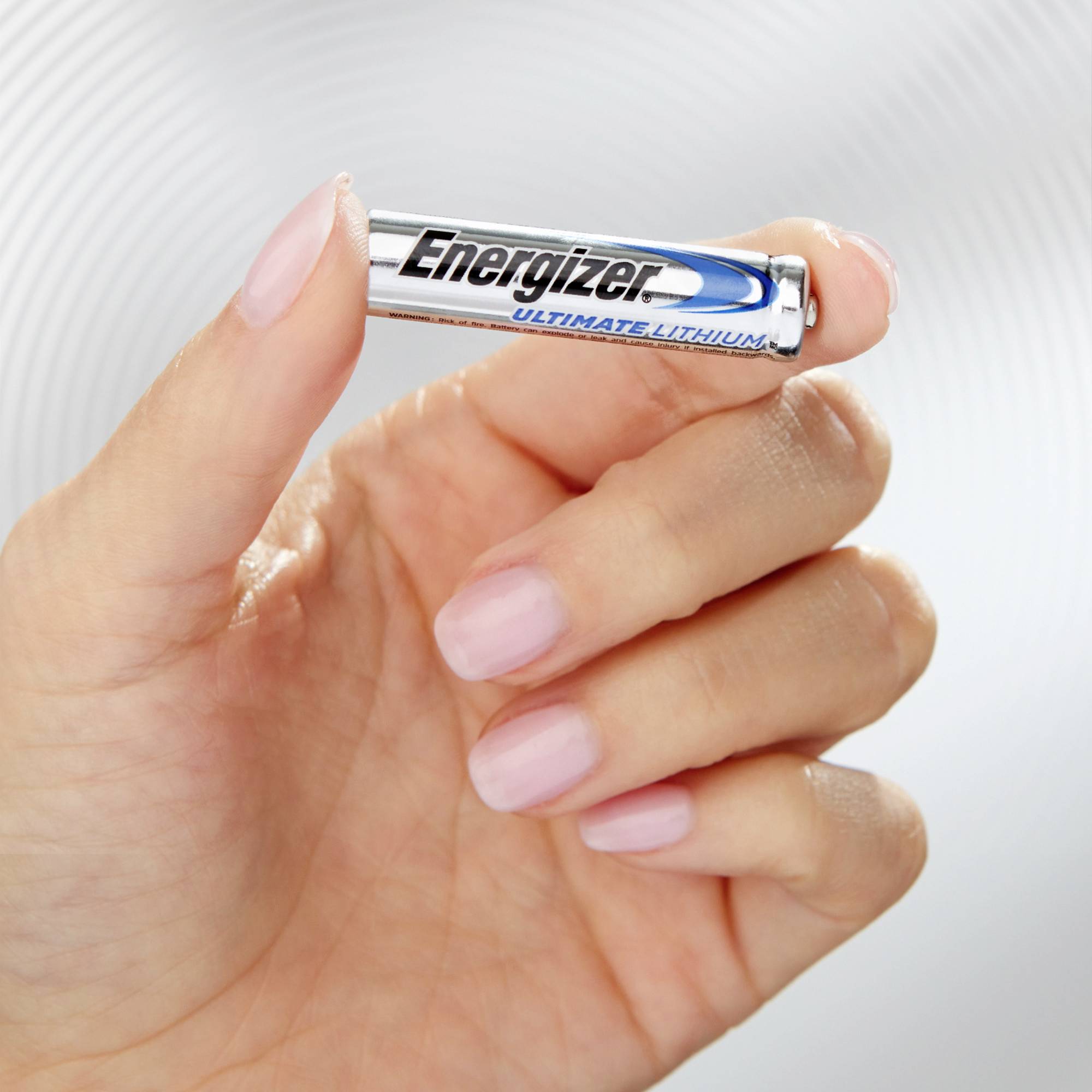 Eine Hand hält eine Energizer Ultimate Lithium-Batterie. Die Batterie hat ein silbernes Gehäuse mit blauer und schwarzer Schrift.