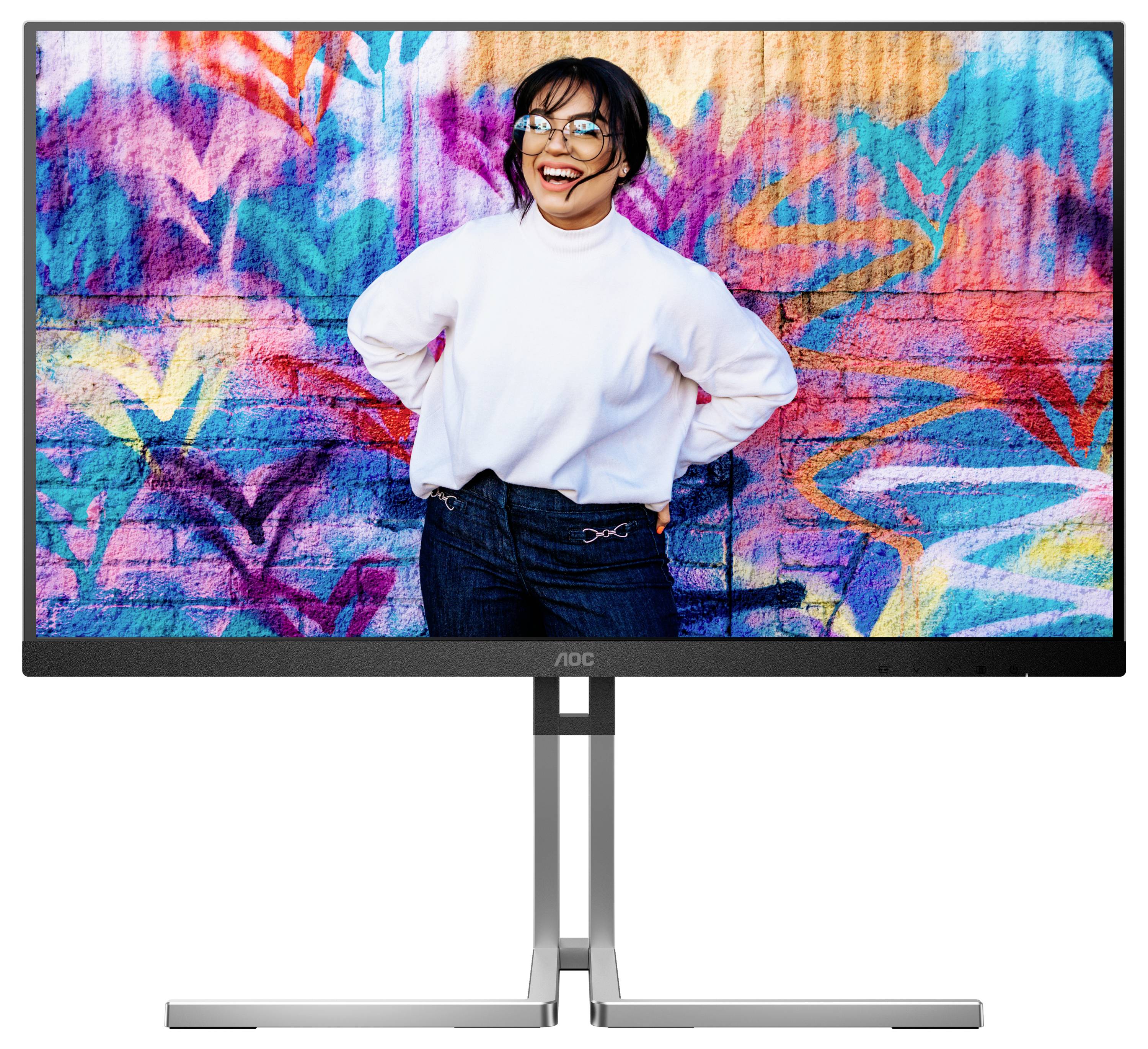 Frau in weißem Pullover lächelt vor einer bunten, farbenfrohen Graffiti-Wand. Sie steht in entspannter Pose und wirkt fröhlich.