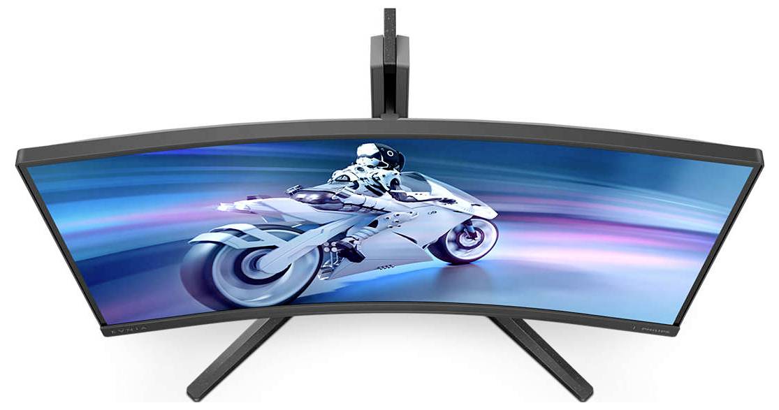 Gekrümmter Gaming-Monitor mit einem futuristischen Motorrad und Science-Fiction-Motorradfahrer auf dem Bildschirm, strahlendes Blau.