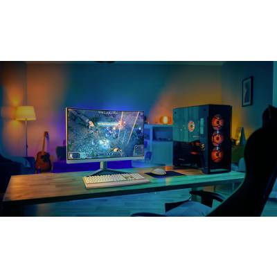 Ein moderner Gaming-PC und Monitor auf einem Schreibtisch in einem gemütlich beleuchteten Raum. Auf dem Bildschirm läuft ein Videospiel.